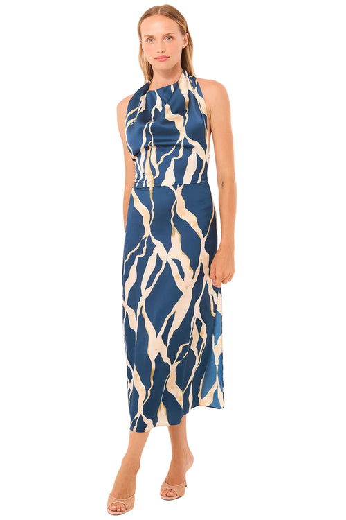 Woman wearing a blue and white patterned dress on a beige background