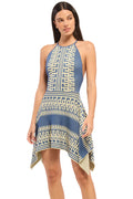 Woman wearing a blue and white patterned dress on a plain background