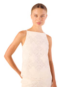 Woman wearing a white quilted dress against a plain background