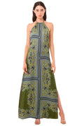 Woman wearing a green patterned halter neck dress on a beige background