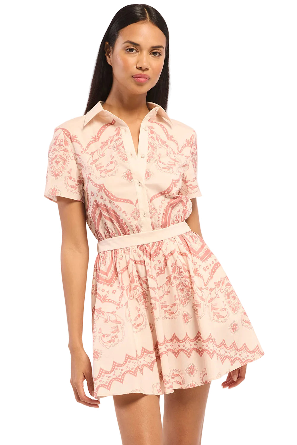 Woman wearing a pink and white patterned dress on a plain background