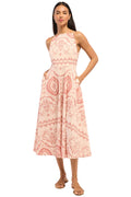 Woman wearing a pink patterned dress on a white background