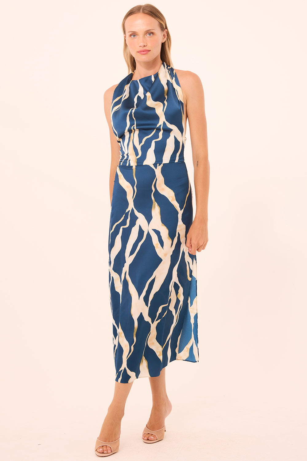 Woman wearing a blue and white patterned dress on a beige background